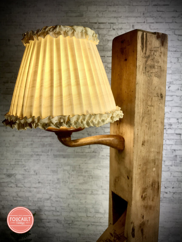 Langhobel mit alter Stoff-Nachttischlampe an Holzbogen auf Wurzelholz